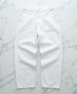 Mode Of One white baggy-fit jeans laid flat on a marble surface, emphasizing the crisp color and expansive cut.